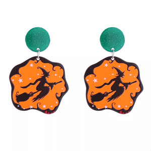Spooky dangle earrings with green glitter tops and orange witch silhouette design.