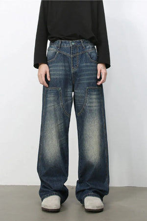 Artisan distressed wide-leg jeans in medium wash denim with unique pocket details.