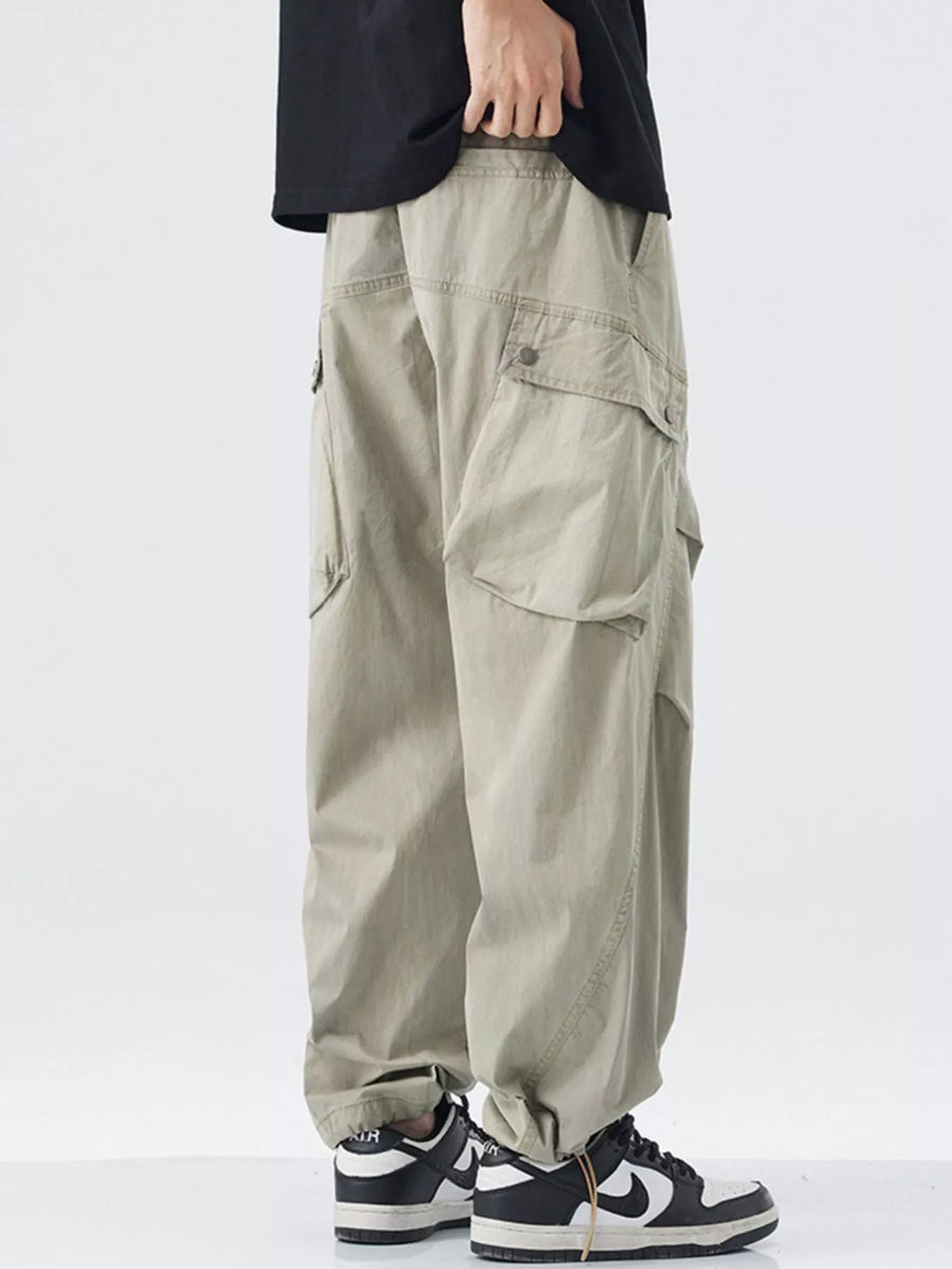 Khaki loose fit cargo pants with multiple pockets and drawstring detail.
