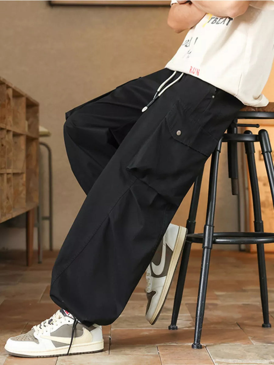 Black cargo pants with drawstring waist and button-flap pockets