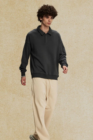 Oversized dark gray polo sweatshirt with collar and long sleeves.
