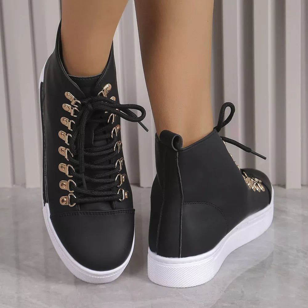 Black lace-up platform sneakers with gold D-ring eyelets and white soles.