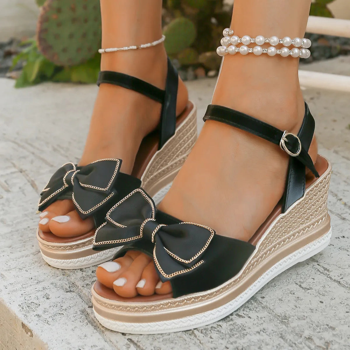 Black espadrille wedge sandals with bow detail and ankle strap.