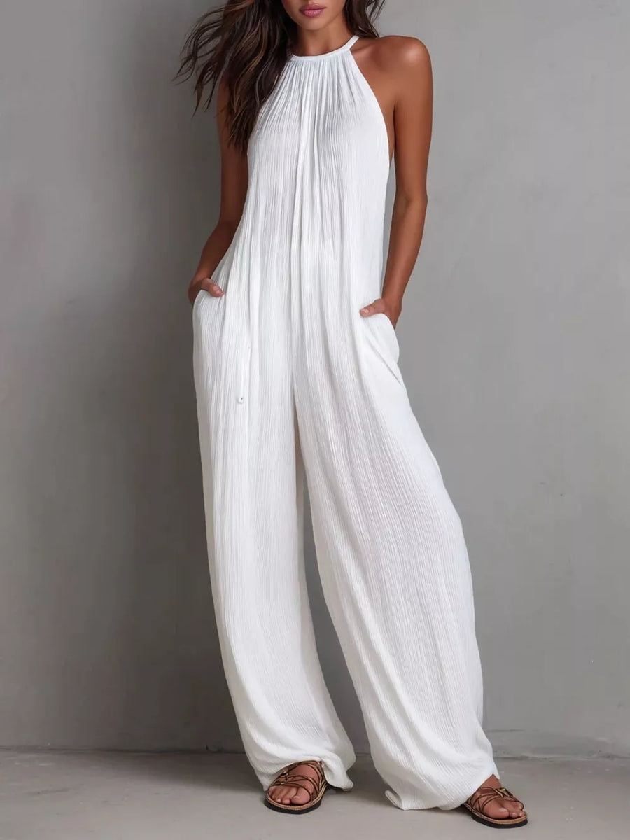 White wide-leg jumpsuit with halter neck and textured fabric.