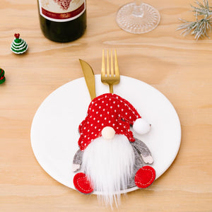 Festive red polka dot gnome cutlery holder with white beard and red feet.