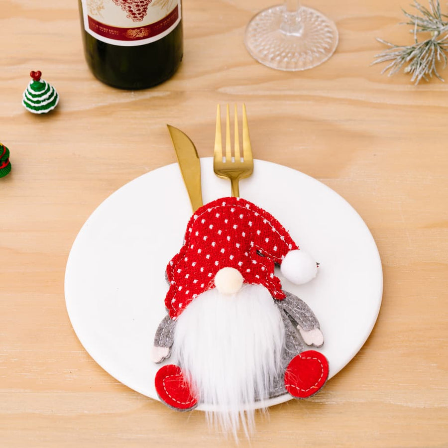 Festive red polka dot gnome cutlery holder with white beard and red feet.