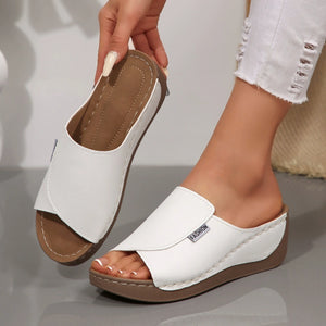 White open-toe wedge sandals with a slip-on design and "FASHION" detail.