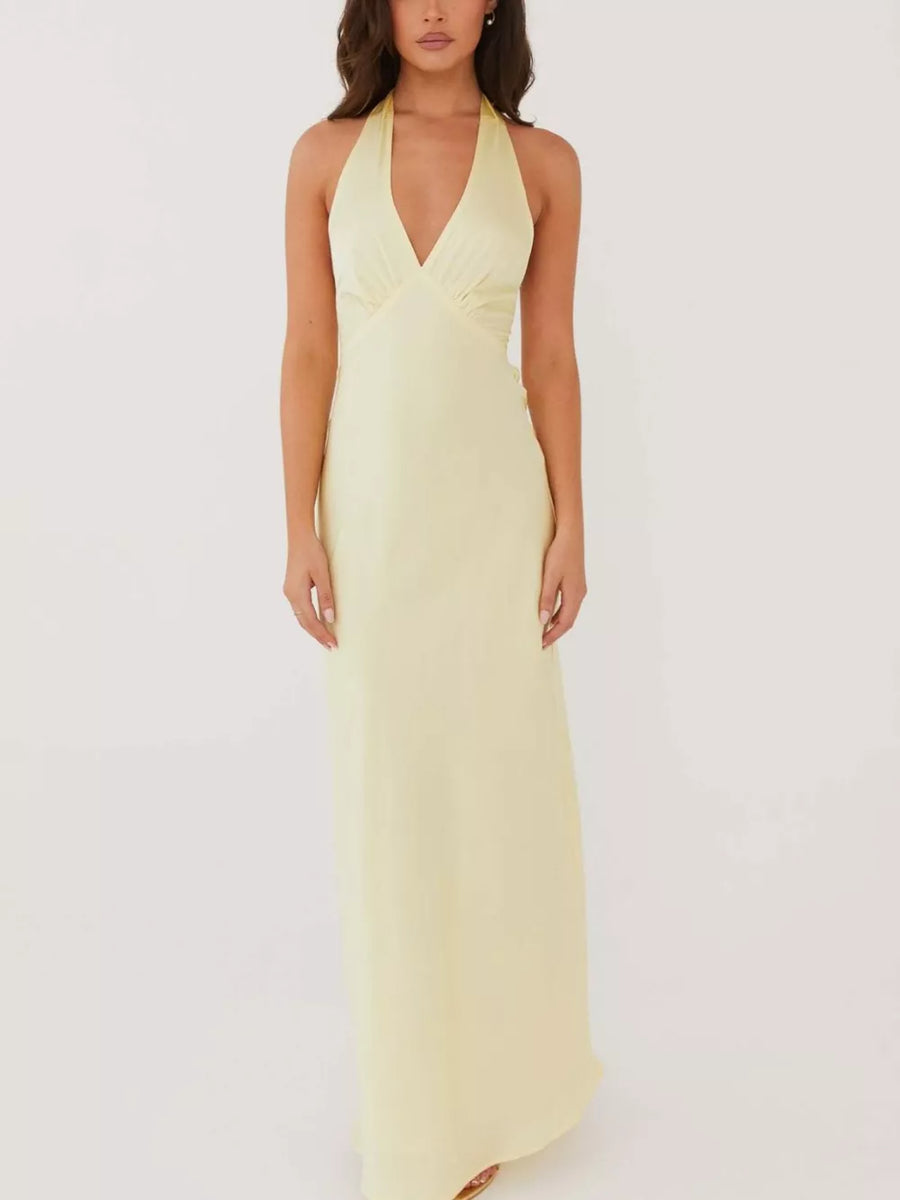 Pastel yellow cotton backless halter neck maxi dress with deep V-neck.
