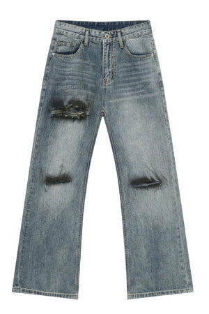 Distressed flare leg jeans in medium wash cotton denim with ripped details.