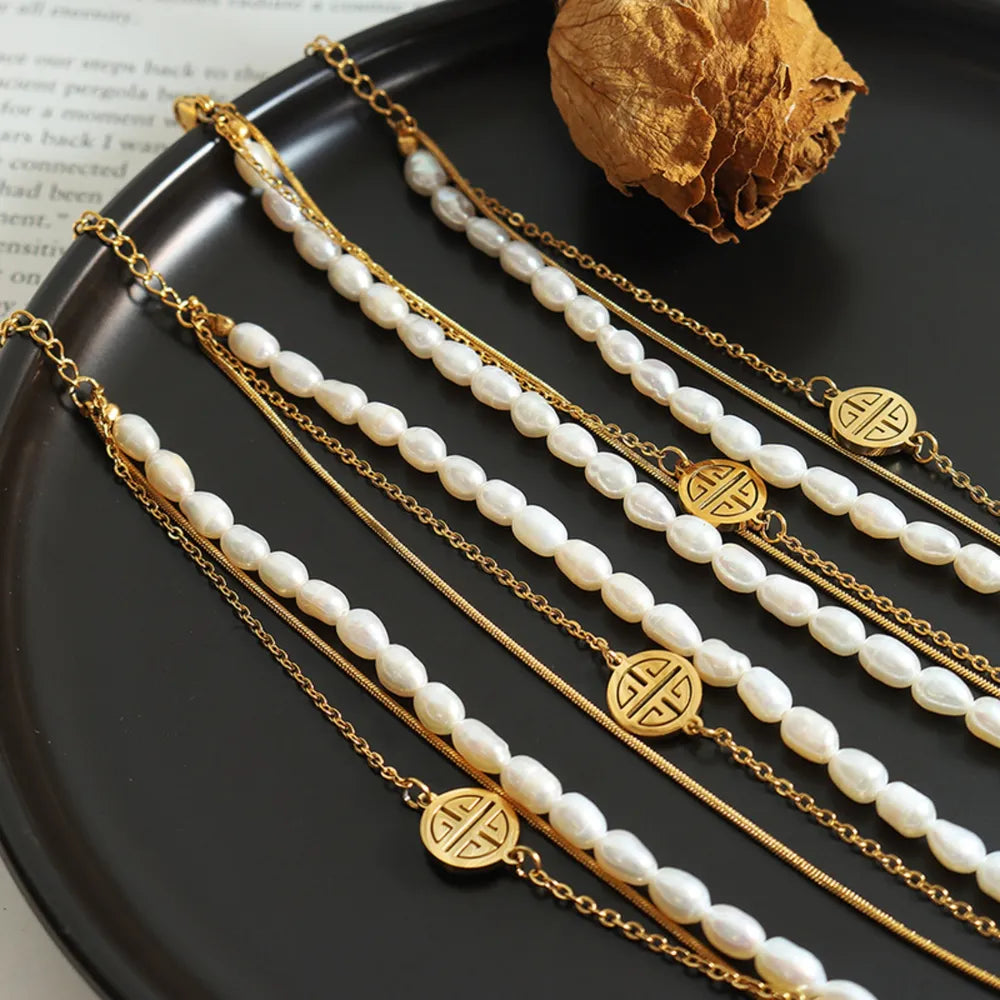 Gold layered bracelet with pearls, chains and circular charms