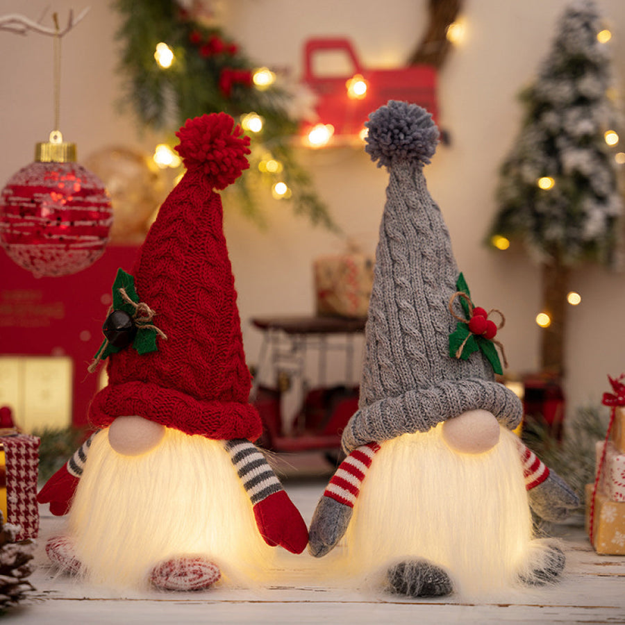Illuminated knit gnomes in deep red and light gray with pom-pom hats and striped sleeves.