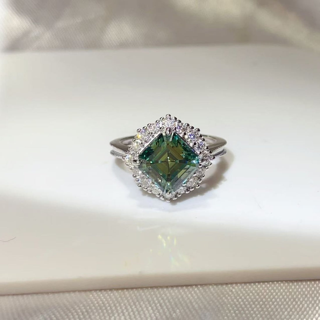 ring in emerald green featuring halo setting and fitted fit