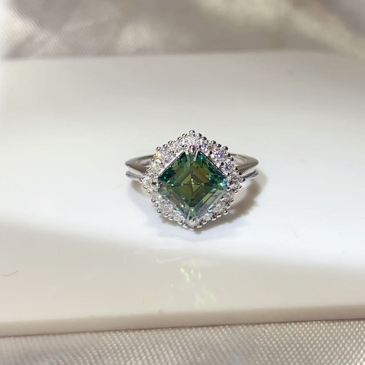 ring in emerald green featuring halo setting and fitted fit