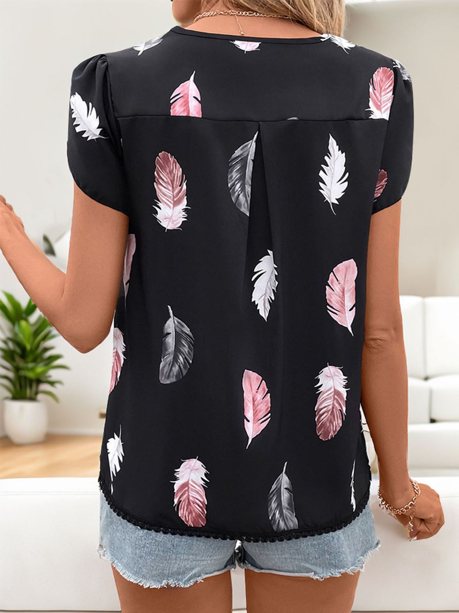 Black feather print blouse with puff sleeves and a lace hem