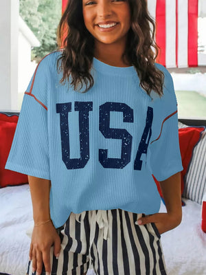 Light blue ribbed knit t-shirt with distressed USA graphic and contrast stitching.