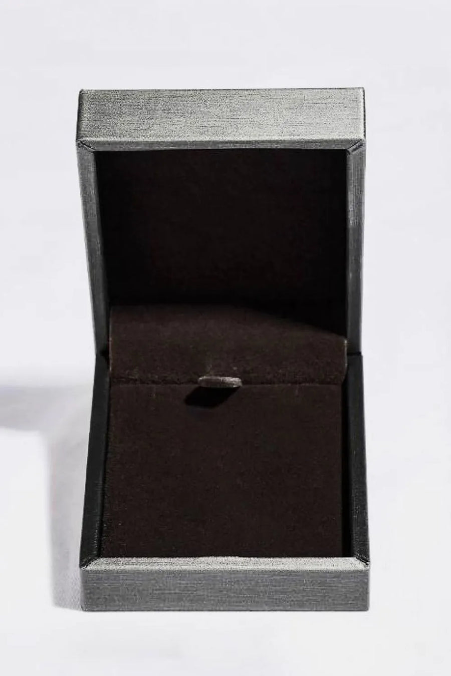 Open jewelry box with dark green velvet lining and silver textured exterior.