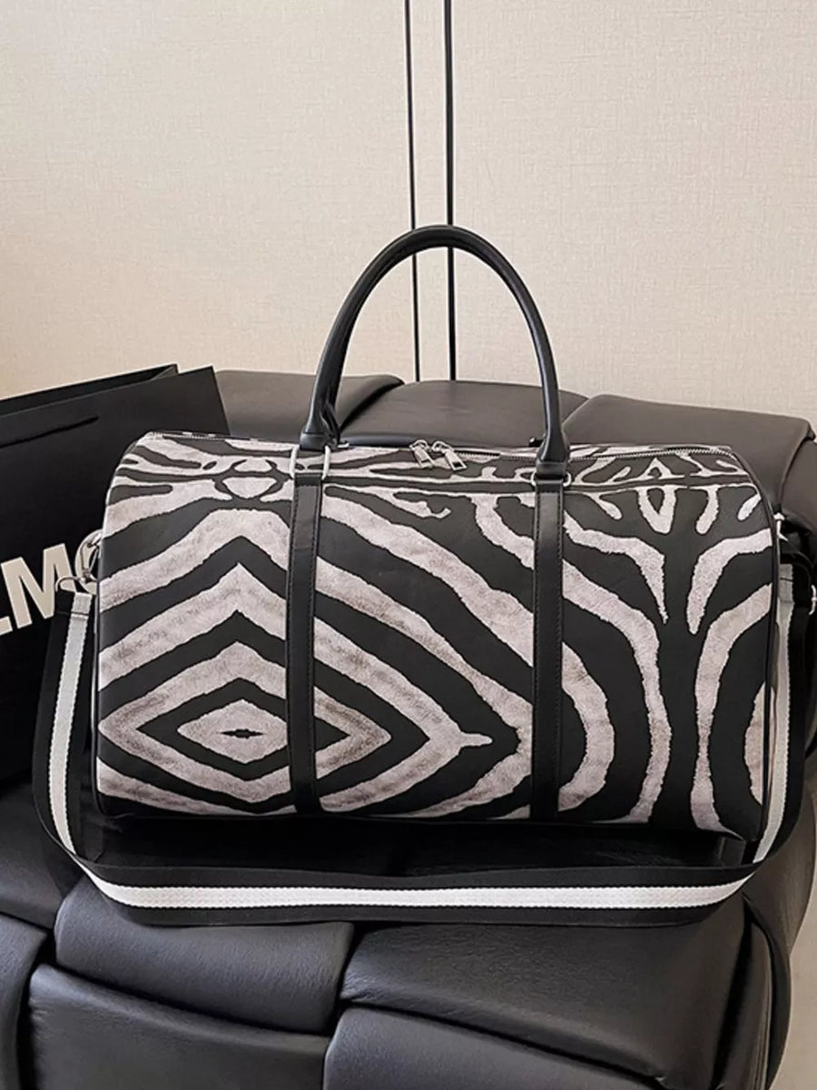 Large black and white zebra print duffle bag with carry handles and detachable strap.
