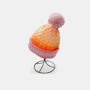 Textured ombre knit beanie with pink pom and ribbed band, transitioning from orange to pink.