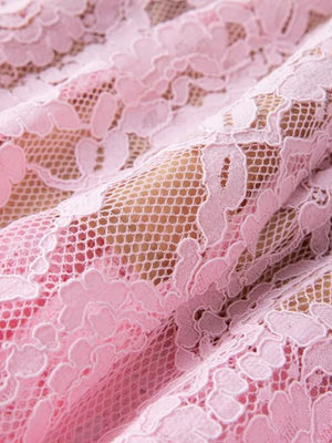 Pink lace dress with floral pattern and pearl embellishments.