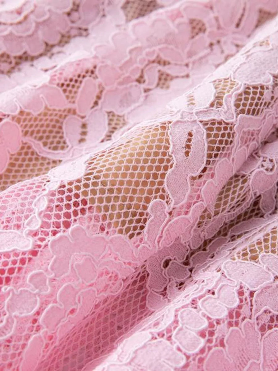 Pink lace dress with floral pattern and pearl embellishments.