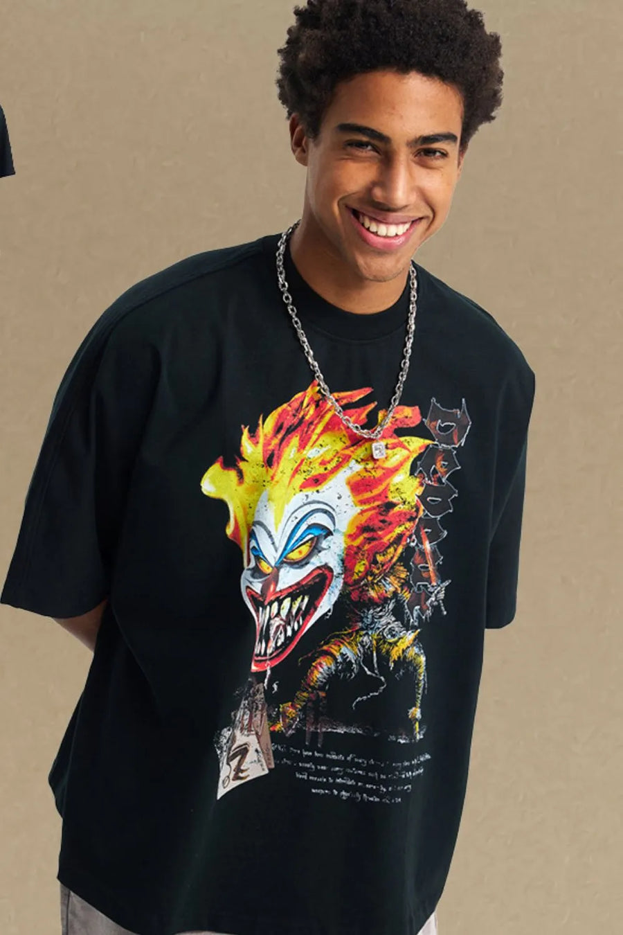 Black oversized t-shirt with a bold clown graphic featuring flames and sharp teeth.