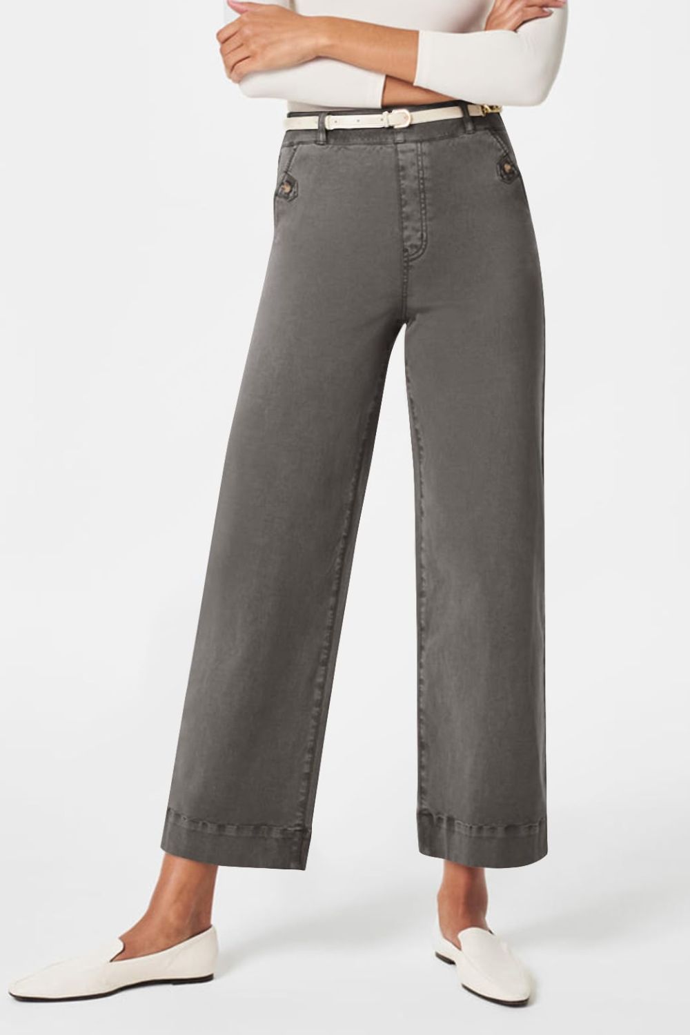 Wide-leg utility denim trousers in dark gray with button details and a white belt.