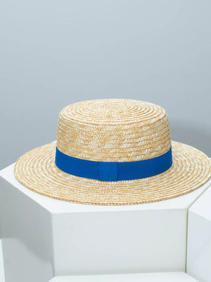 Women's boater sun hat in natural straw with a royal blue ribbon band.