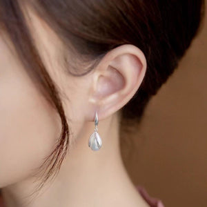Lustrous pearl drop earrings in silver with a delicate petal design.