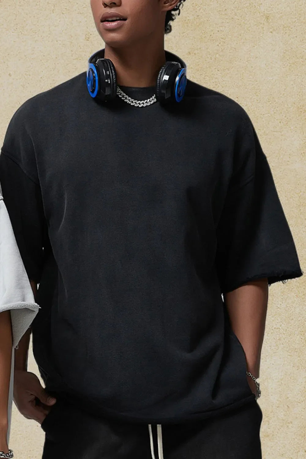 Black boxy t-shirt with raw edge sleeves and hem, crew neck, short sleeves.