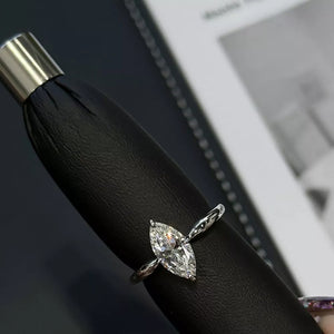 Diamond marquise engagement ring with a textured band in white gold.