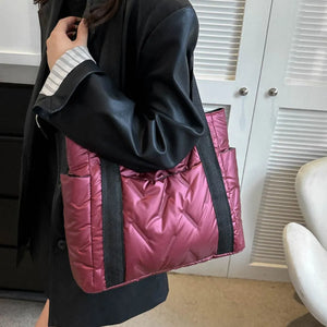 Padded nylon tote bag in deep red with exterior pockets and chevron quilting.