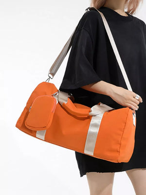Orange duffle bag with detachable pouch and silver stripe detail, worn crossbody.