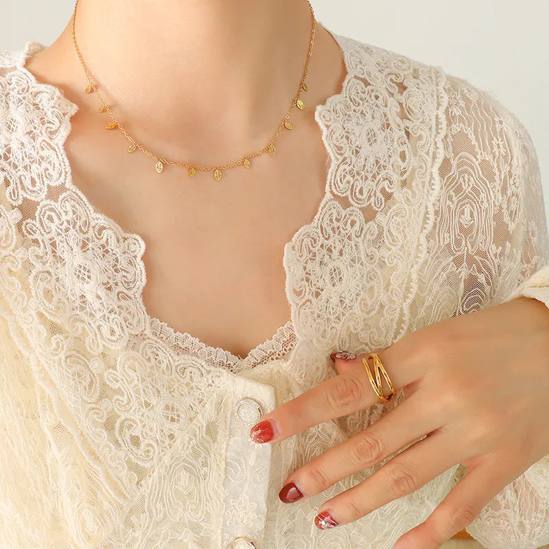 Gold Leafs dangling charm chain necklace with delicate leaf charms on a fine chain.