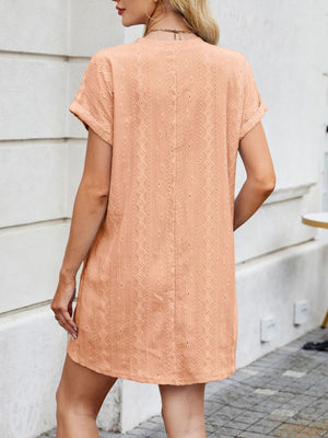 Eyelet mini dress in peach with diamond pattern, crew neck, short sleeves, and A-line cut.