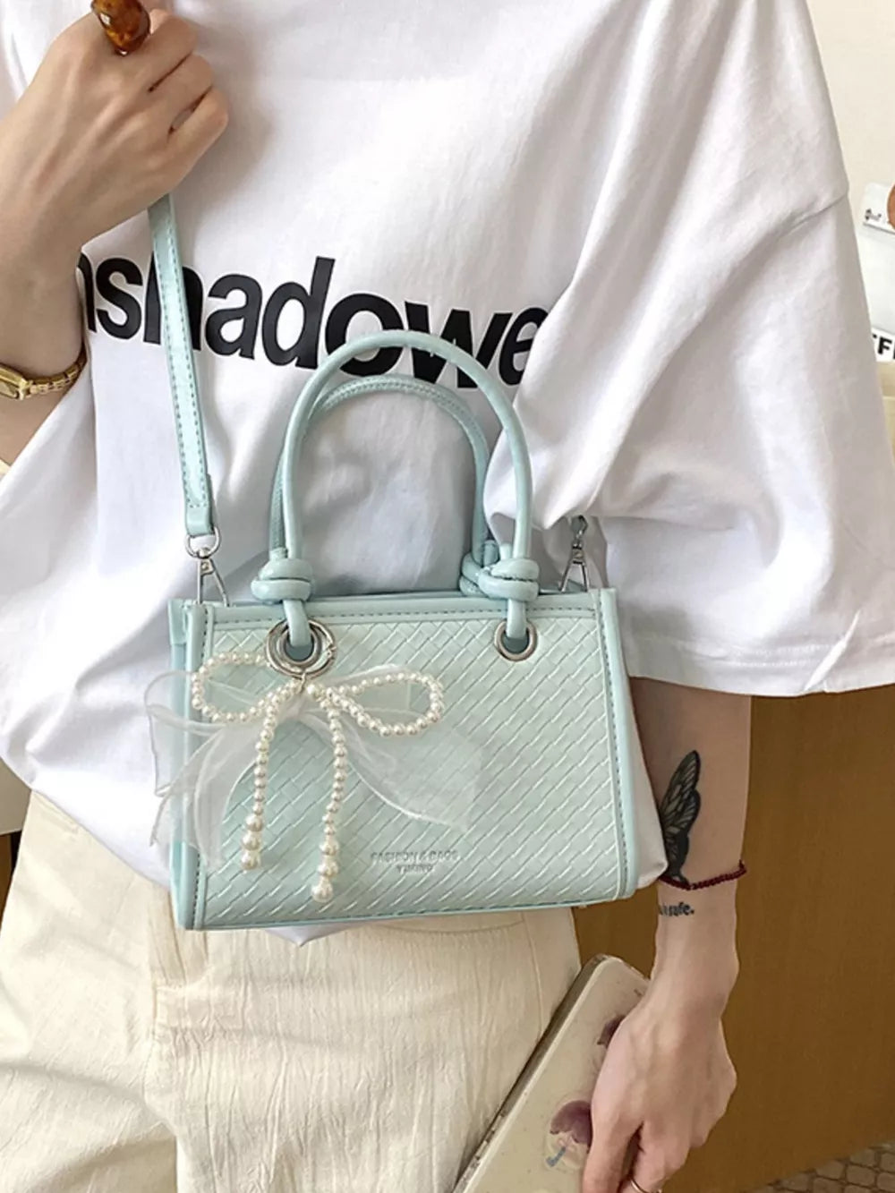 Pastel Blue crossbody bag featuring bow embellishment and geometric