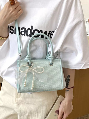Pastel Blue crossbody bag featuring bow embellishment and geometric