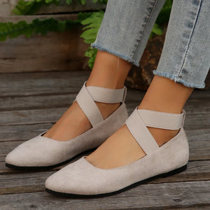 Beige crisscross strap pointed-toe ballet flats with elastic ankle straps.