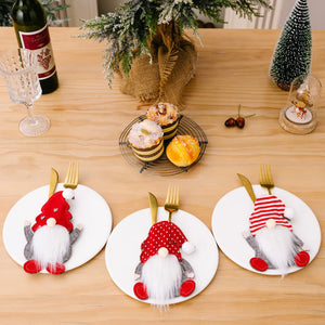 Festive gnome cutlery holders in red with white accents, a cheerful holiday table accessory.