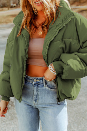 Moss green padded crop jacket with stand collar and zip front, styled with jeans.