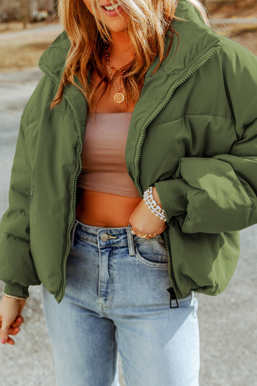 Moss green padded crop jacket with stand collar and zip front, styled with jeans.