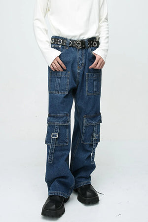 Medium wash denim cargo pants with buckle pockets and straps.