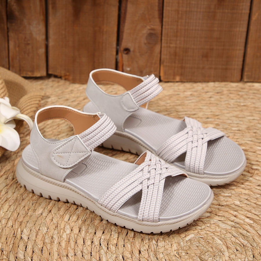 Gray woven strap open-toe flat sandals with adjustable straps and a thick sole.