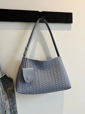 Blue woven shoulder bag with leather detail and braided strap.