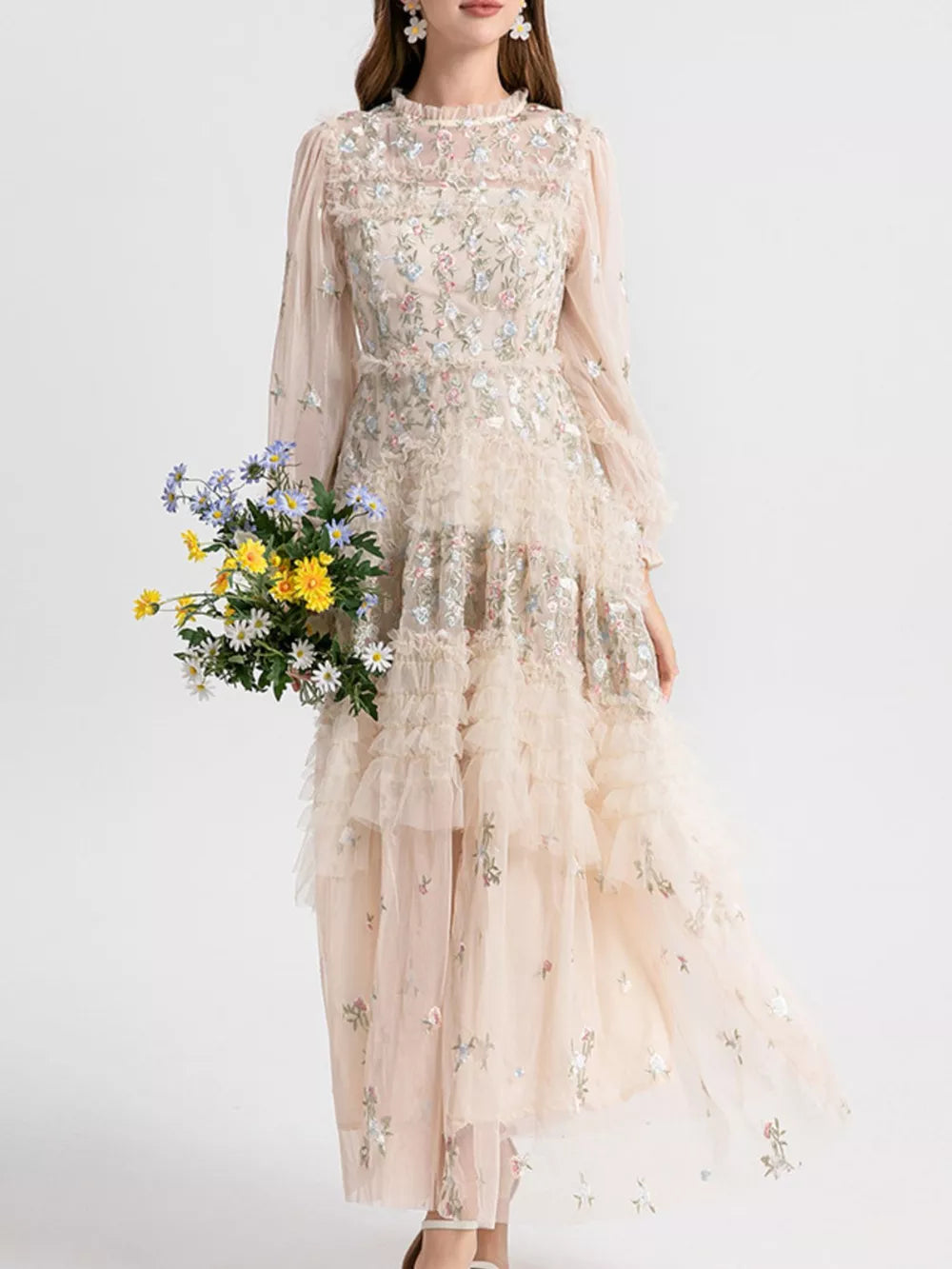 Embroidered floral tulle maxi gown with ruffled tiers and long sleeves.