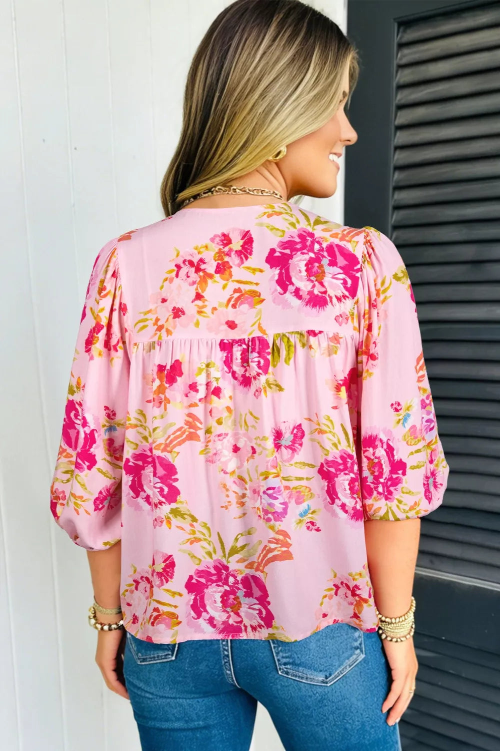 Pink floral tie-neck blouse with gathered yoke and puff sleeves.