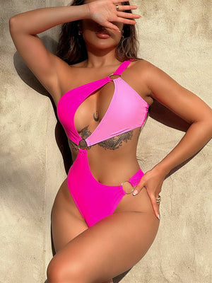 Hot pink one-piece swimsuit with asymmetric ring detail and cut-out sides