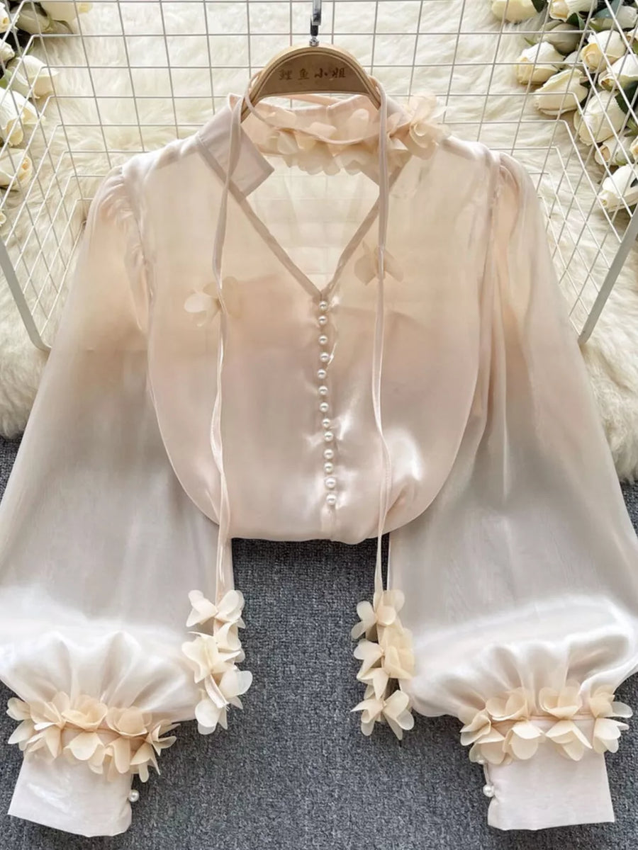 Apricot sheer button-down shirt with delicate floral appliqué and pearl buttons.