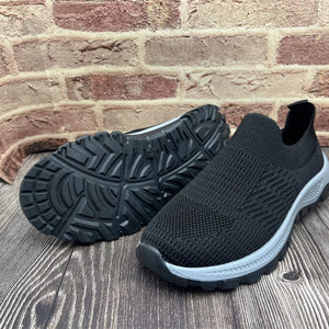 Black breathable knit slip-on sneakers with grey soles and textured tread.