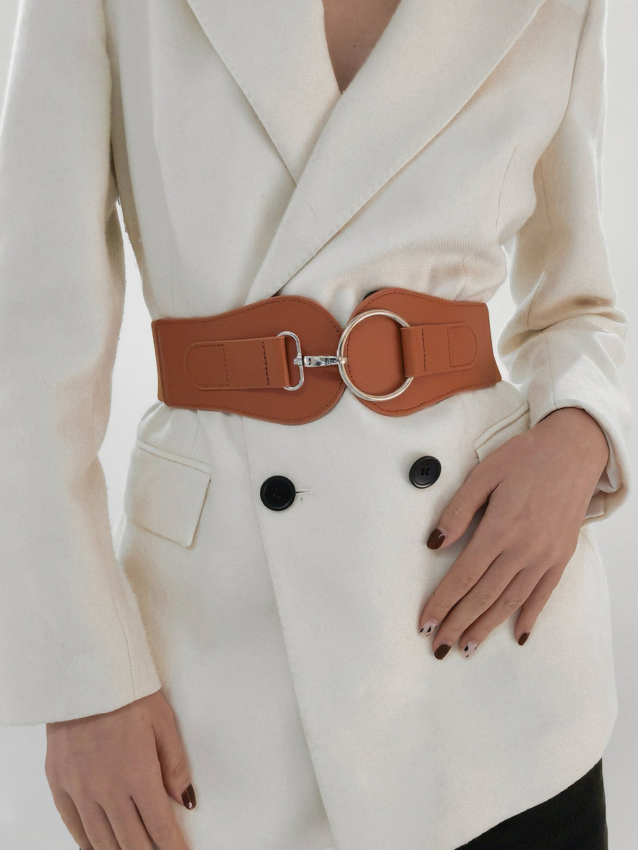 Caramel elastic cincher belt with silver buckle and ring detail worn over a white blazer.