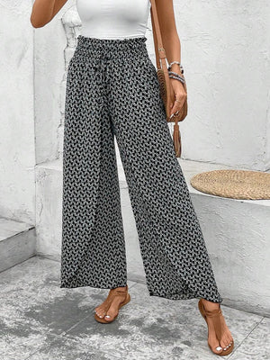 Black and white patterned palazzo pants with a smocked waist and tie detail.